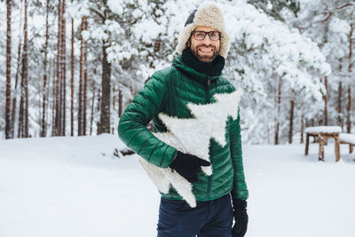 Young man standing on snow covered land