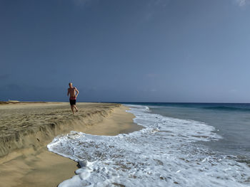 Full length of man on beach against sky
