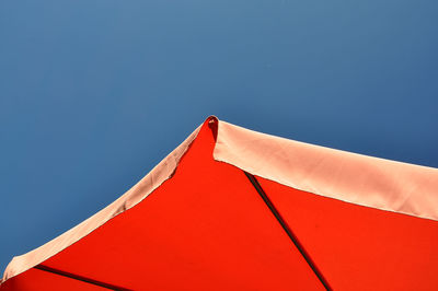 Red parasol against a blue sky