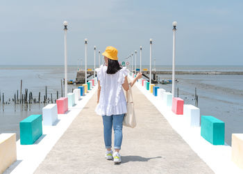 The back of woman walking on the rainbow bridge to see the viewpoint at the samut sakorn province, 