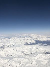 Scenic view of snowcapped mountains against clear blue sky