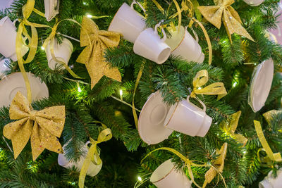 Christmas and new year holidays background. christmas tree decorated with white cups ans sauces. 