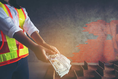 Low angle view of man working against orange wall