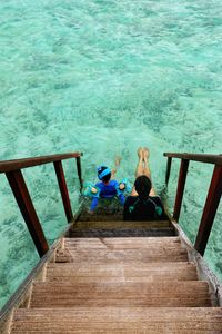 High angle view of people sitting on steps over sea