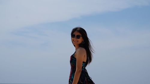 Portrait of woman wearing sunglasses standing against sky