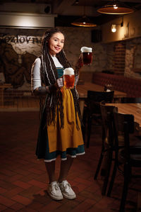 A young waitress with two pints of beer in her hand in a beer pub