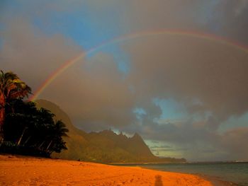 Scenic view of rainbow over sea against sky