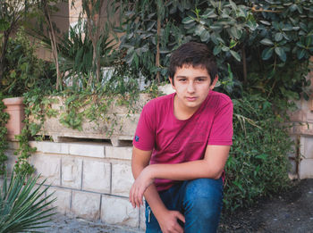 Portrait of young man sitting in yard