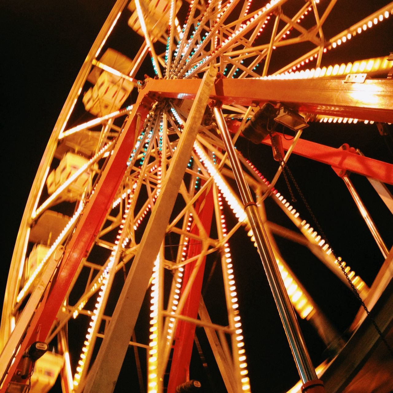 illuminated, night, low angle view, arts culture and entertainment, metal, amusement park, amusement park ride, built structure, red, metallic, ferris wheel, no people, architecture, outdoors, engineering, lighting equipment, pattern, connection, sky, glowing