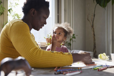 Mother and daughter drawing together