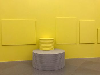 Tiles stacked by yellow wall