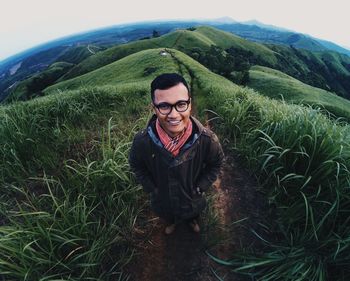 Portrait of smiling young woman standing on field
