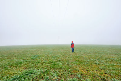 Rear view of man on field against sky