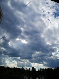 Low angle view of silhouette trees against sky