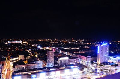 Illuminated cityscape against sky at night