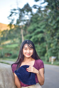 Portrait of beautiful young woman using phone while standing outdoors