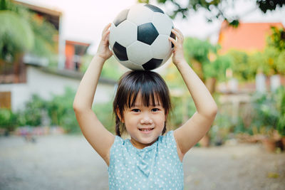 Portrait of smiling boy with ball in background