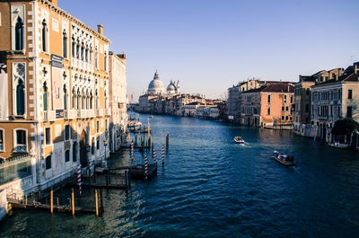 Boats in canal amidst buildings in city