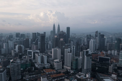 Aerial view of buildings in city against sky