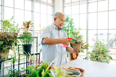 Man standing by potted plant