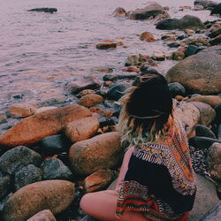 Rear view of woman sitting at beach