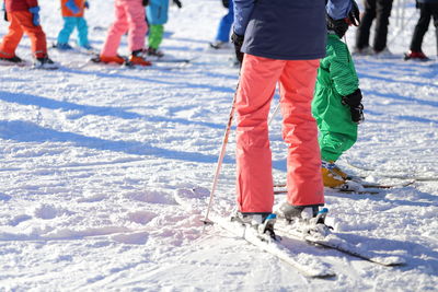 Low section of people skiing on snow covered landscape