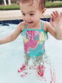 Cute boy drinking water in swimming pool