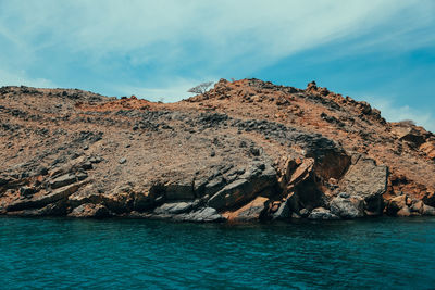 Scenic view of rocks in sea against sky