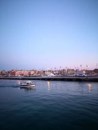 Scenic view of sea and buildings against clear blue sky