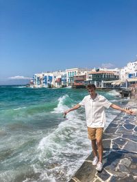 Full length of person standing at sea shore against sky