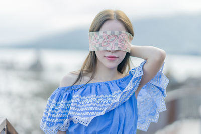 Portrait of happy girl standing against sea