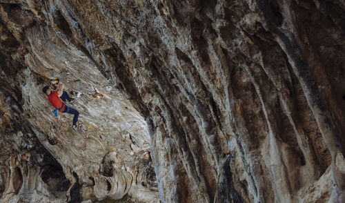 Climber sending a hard sport climbing route in a cave.