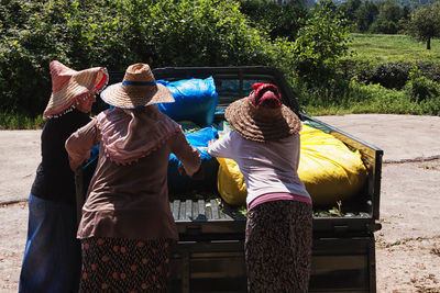 Women loading tea leaves in sacks on pick-up truck