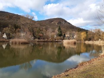 Scenic view of lake by mountains against sky