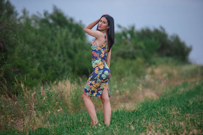 Full length of happy woman standing on field