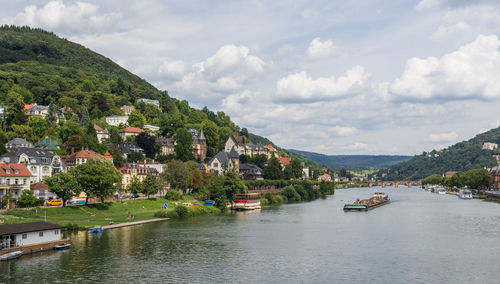 Scenic view of river by town against sky