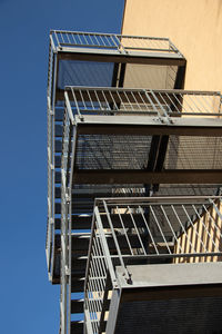 Low angle view of staircase against clear blue sky