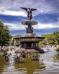 Statue of fountain in lake against sky