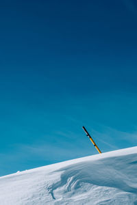 Low angle view of snow against blue sky