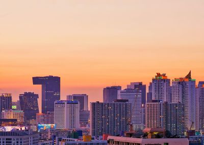 Modern buildings against sky during sunset