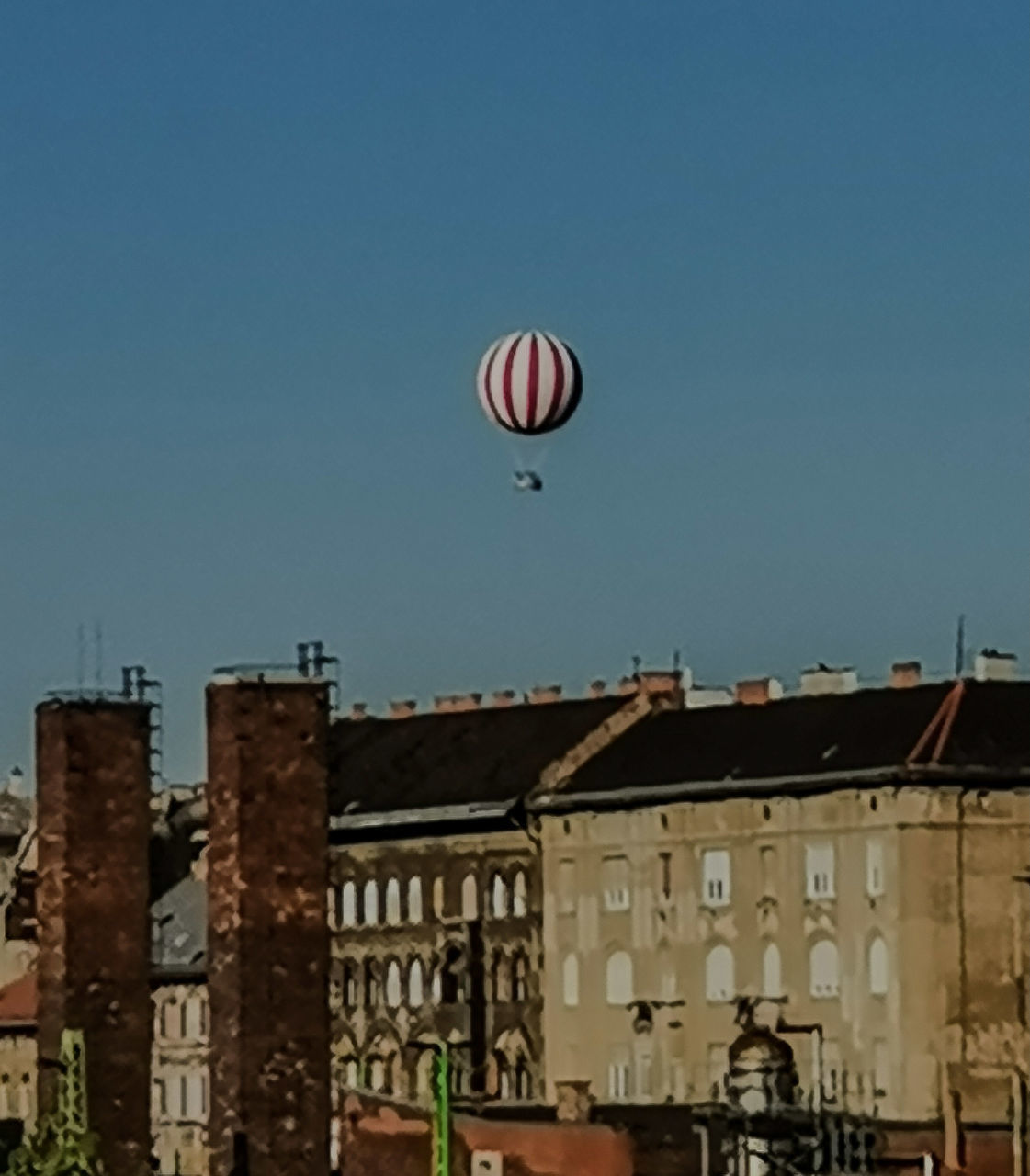 hot air balloon, architecture, sky, built structure, building exterior, vehicle, aircraft, clear sky, nature, city, transportation, balloon, mid-air, building, no people, outdoors, day, sports, flying