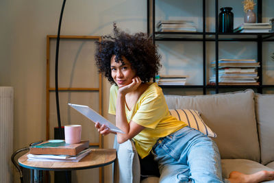 Portrait of young woman sitting at home