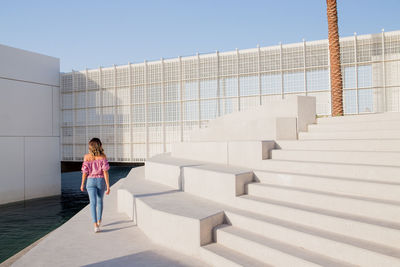 Rear view of woman standing on staircase