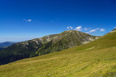 Scenic view of mountains against blue sky