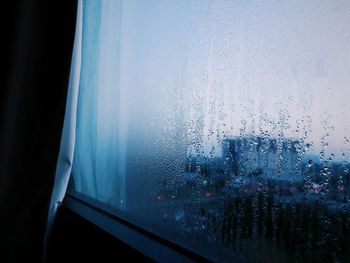 Close-up of car window against sky