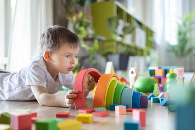 Boy playing with toy blocks on table