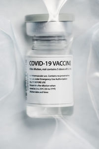 Medical glass vial of booster of coronavirus vaccine sealed on plastic bag