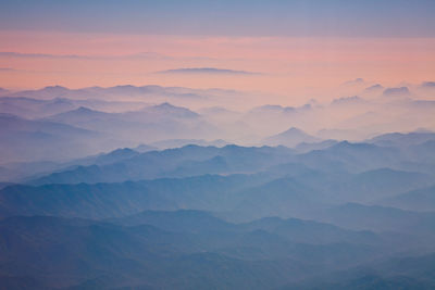 Scenic view of foggy mountains at sunrise