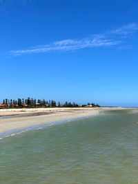 Scenic view of beach against blue sky