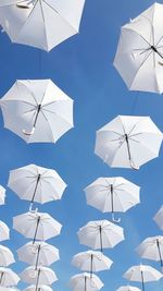 Low angle view of umbrellas hanging against sky